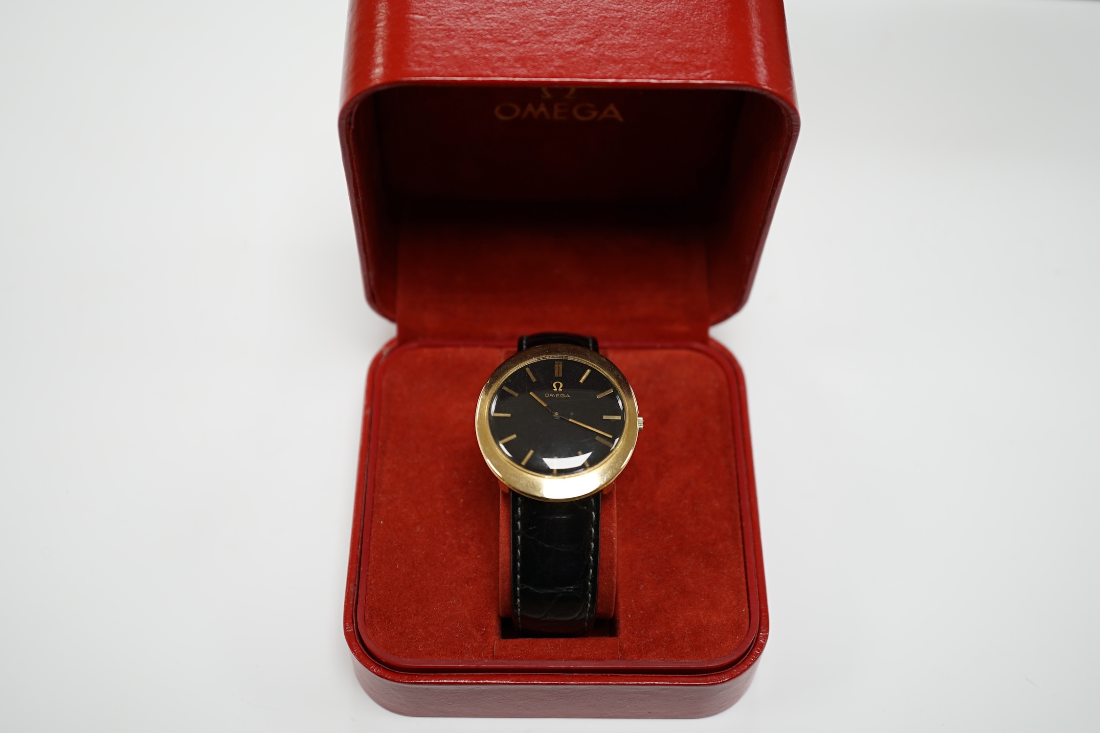 A gentleman's 9ct gold black dial manual wind wrist watch, with Omega box.